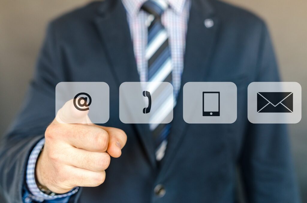 man pointing at the at sign for contact info